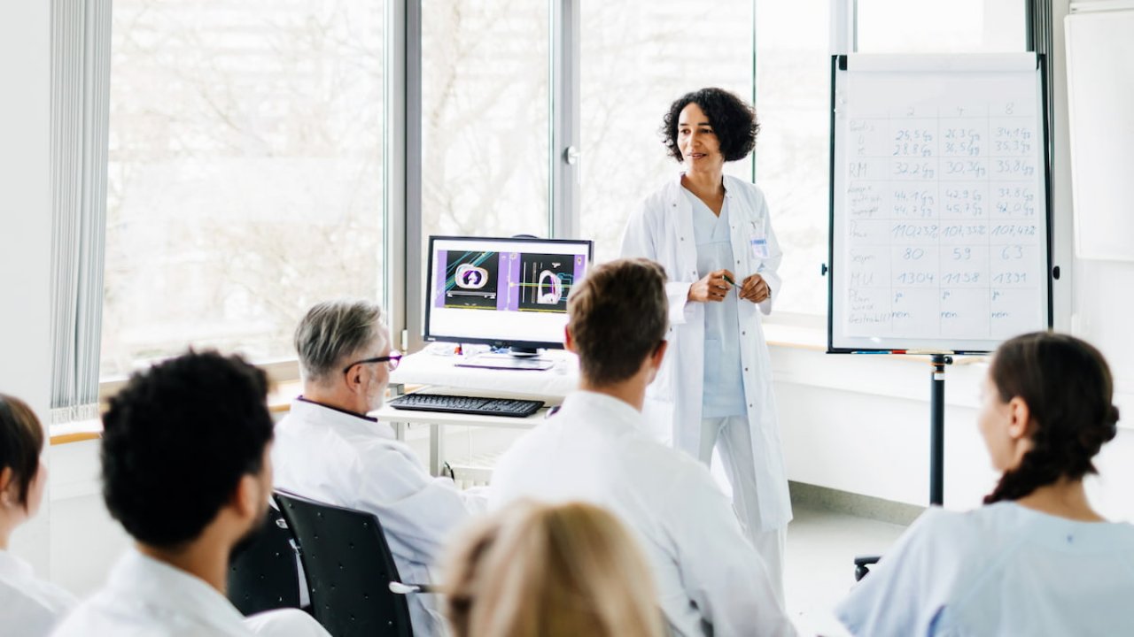 A nuclear medicine expert presenting the latest findings in theranostics for oncology at a medical education seminar.